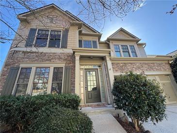 Charming two-story home featuring a stone facade, green shutters, and attached garage at 3740 Crowchild Dr, Cumming, GA 30041