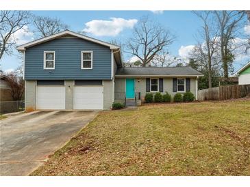 Charming home with a teal door, two-car garage and blue and grey accents at 2235 Emerald Springs Dr, Decatur, GA 30035
