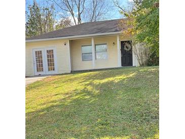 Charming single-story home featuring a well-manicured lawn and a welcoming front door with a decorative wreath at 304 Deerfield Dr, Jonesboro, GA 30238