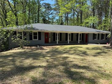 Charming single-story home with a gray brick exterior, front porch, and well-maintained lawn at 2899 Tejas Sw Trl, Atlanta, GA 30331