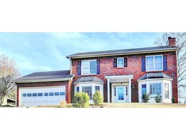 Two-story brick home with a two car garage and manicured lawn, offering classic charm at 161 Muddy River Rd, Lawrenceville, GA 30043