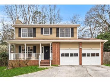 Charming two-story home with brick accents, front porch, and attached two car garage at 3775 Norman Rd, Clarkston, GA 30021