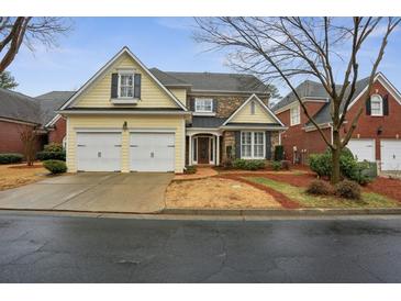 Attractive two-story home with a two-car garage, stone accents, and manicured landscaping at 6445 Glen Oaks Ln, Atlanta, GA 30328