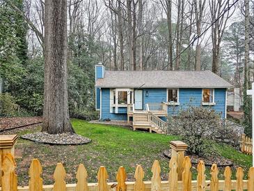 Charming blue home with a picket fence and well-maintained lawn and inviting front porch at 2336 Vistamont Dr, Decatur, GA 30033