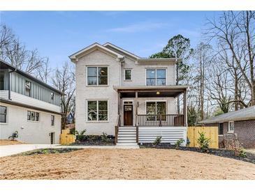 Charming two-story home featuring a covered front porch and a freshly landscaped yard at 1055 Ormewood Se Ave, Atlanta, GA 30316