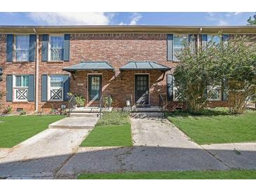 Traditional brick townhome with well-manicured front lawn and inviting entryway at 5678 Kingsport Dr, Sandy Springs, GA 30342