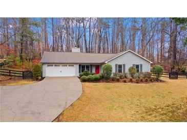 Charming single-story home featuring a well-manicured lawn, a red front door, and an attached garage at 3605 Chattahoochee Rd, Cumming, GA 30041