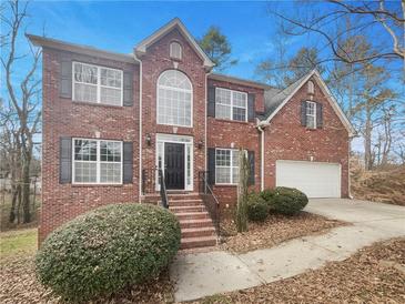 Charming two-story brick home featuring a manicured front yard and attached two-car garage at 5132 Silhouette Sw Ln, Mableton, GA 30126