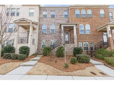 Charming townhome with brick facade, manicured landscaping, and inviting front entry at 3374 Grey St, Duluth, GA 30096
