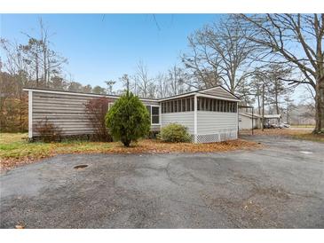 Charming home with a screened porch and mature trees surrounding the property at 428 Rainey Rd, Temple, GA 30179