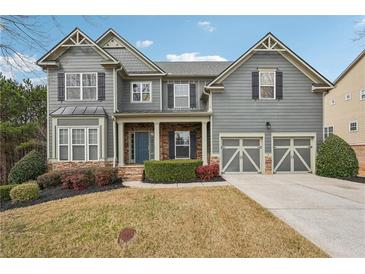 Charming two-story home features a manicured front yard, a blue front door, and a two-car garage at 4450 Sandalwood Way, Cumming, GA 30041