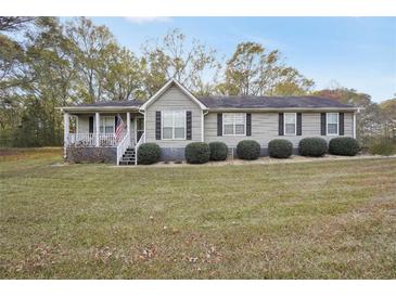 Charming single-story home with a well-manicured lawn and covered front porch at 2096 Old Jackson Rd, Locust Grove, GA 30248