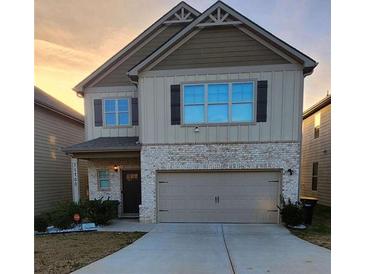 Charming two-story home featuring stone accents, attached two-car garage, and welcoming front porch at 11700 Brightside Pkwy, Hampton, GA 30228