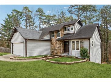 Charming home with stone accents, landscaped yard, and attached two-car garage at 5368 Stafford Nw Dr, Lilburn, GA 30047