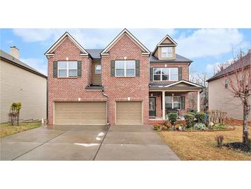 Two-story brick home featuring an attached two-car garage and well-manicured landscaping at 2656 Muskeg Sw Ct, Atlanta, GA 30331