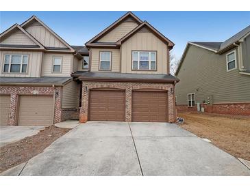 Townhome with brick and siding, featuring a two-car garage and a concrete driveway at 1211 Grampian Pass # 15, Marietta, GA 30008