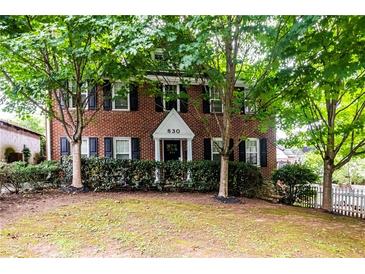 Charming brick home with lush trees, black shutters, manicured hedges, and inviting front entrance at 830 Barnett Ne St # 8, Atlanta, GA 30306