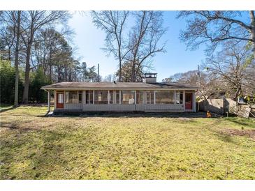 Spacious backyard featuring a charming one-story home with large windows at 382 Golfview Nw Rd, Atlanta, GA 30309