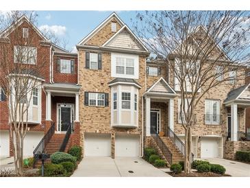 Charming brick townhome with well-manicured landscaping, garages, and inviting front entrances at 2959 Rivergreen Se Ln, Atlanta, GA 30339