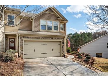 Charming two-story home featuring a stone-accented facade and a spacious two-car garage with a concrete driveway at 3041 Cross Creek Dr, Cumming, GA 30040