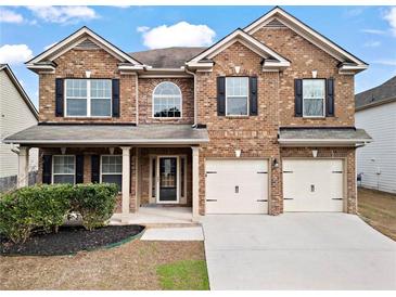 Charming two-story brick home featuring a well-manicured lawn and attached two-car garage at 4102 Dinmont Chase, Atlanta, GA 30349