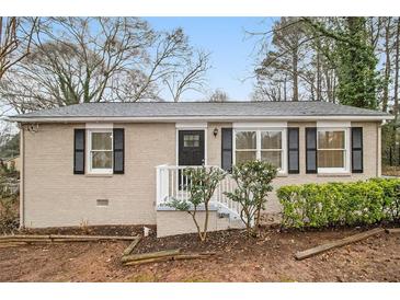 Charming single-story home featuring a brick facade, white trim, and manicured landscaping at 1438 Joy Ln, Decatur, GA 30032