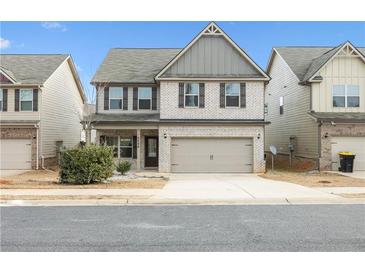 Two-story home featuring brick facade, two-car garage and well-maintained landscaping at 2098 Bridgewater Pass, Hampton, GA 30228