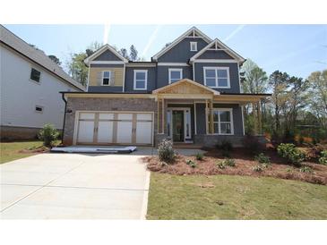 New construction home with a brick and siding exterior, attached garage, and landscaping at 4445 Beechnut Cir, Cumming, GA 30028
