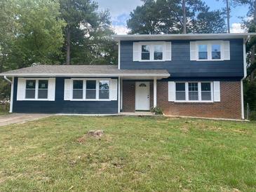 Charming split-level home featuring a brick accent, fresh paint, and bright white shutters and trim at 10664 Sandpiper Road Rd, Jonesboro, GA 30238