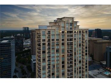 Stunning exterior shot of a tall condo building with a beautiful sunset backdrop at 3445 Stratford Ne Rd # 2403, Atlanta, GA 30326