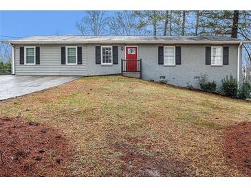 Charming single-story home featuring a gray brick exterior, a well-maintained lawn, and a bright red front door at 3005 Hidden Dr, Lawrenceville, GA 30044