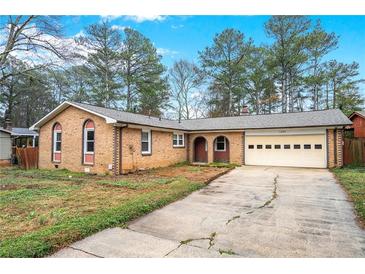 Charming single-story brick home with arched windows and attached garage on a spacious lot at 1495 Harbour Oaks Rd, Tucker, GA 30084