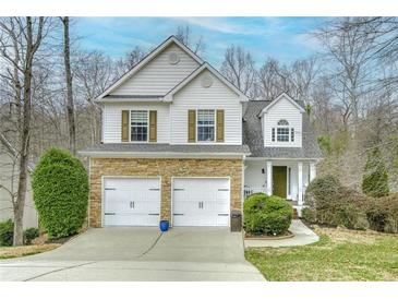 Charming two-story home with stone accents, two-car garage, and well-manicured landscaping at 7045 Shane Ln, Cumming, GA 30028