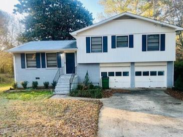 Split level home with blue shutters, gray brick, and a two car garage at 120 Mossy Brook Dr, Stockbridge, GA 30281