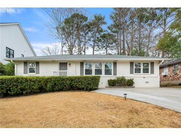 Charming home featuring a white brick facade, well-maintained landscaping, and a welcoming entrance at 1558 Grant Ne Dr, Atlanta, GA 30319