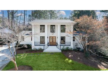 Stunning two-story home with a well-manicured lawn, white brick exterior, and stately columns at 2231 Fairoaks Rd, Decatur, GA 30033