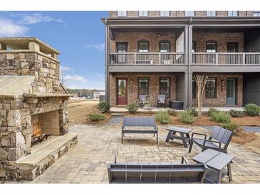 Inviting brick patio with stone fireplace and ample seating for outdoor gatherings at 6785 Pippin Walk, Alpharetta, GA 30005