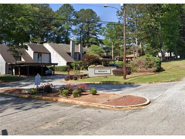 A view of the Willowick community entrance with lush landscaping and well-maintained townhomes visible in the background at 43 Willowick Ct, Stonecrest, GA 30038