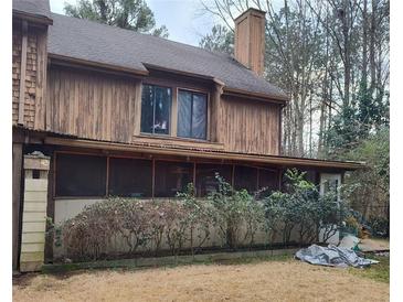 View of the home's side, showcasing the screened porch and natural wood exterior at 43 Willowick Ct, Stonecrest, GA 30038