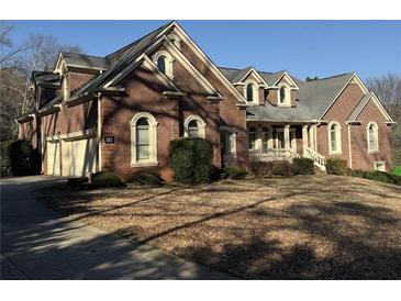 Charming brick home featuring a well-manicured lawn and a two-car garage at 589 Cook Dr, Ellenwood, GA 30294