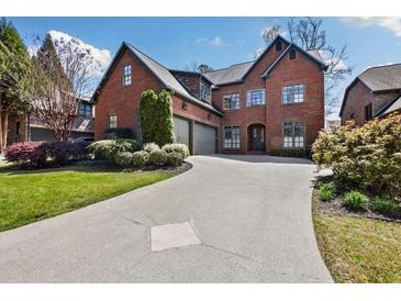 Stunning brick home features manicured landscaping and a long, elegant driveway leading to a two-car garage at 29 Cliftwood Dr, Atlanta, GA 30328