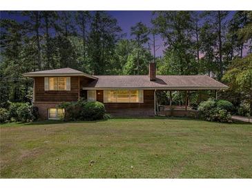 Charming home with a covered porch, a chimney, and a large front yard at 1007 E Callaway Sw Rd, Marietta, GA 30060