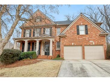 Beautiful two-story brick home with a charming front porch and manicured landscaping at 1085 Highland Crest Ct, Mableton, GA 30126