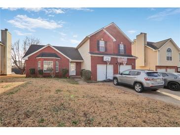 Charming two-story home with brick facade and a two-car garage with basketball hoops at 6153 Idlewood Pass, Lithonia, GA 30038