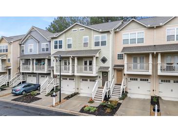 Charming townhomes featuring attached garages, quaint balconies, and welcoming staircases, all with colorful exterior finishes at 1152 Liberty Nw Pkwy, Atlanta, GA 30318