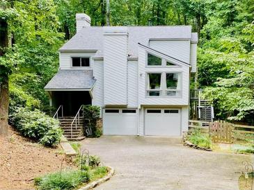 Charming home with a two-car garage and beautiful landscaping surrounded by lush greenery at 2690 Twin Creek Ct, Marietta, GA 30062