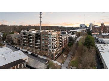 Brick apartment building with balconies and city skyline view on a sunny day at dusk at 675 Drewry Ne St # 602, Atlanta, GA 30306