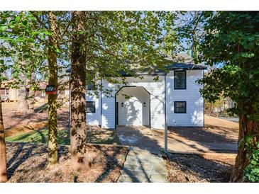 Charming two-story home with white siding and stone walkway, nestled among mature trees in a neighborhood setting at 1314 N Lea Se Ct, Smyrna, GA 30080