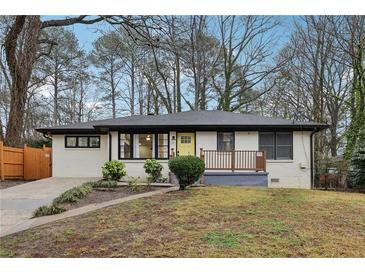 Charming ranch-style home featuring a yellow front door and landscaped yard at 1090 Indale Sw Pl, Atlanta, GA 30310