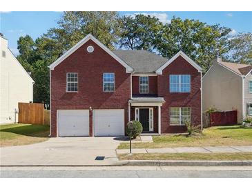 Charming brick home with a well-manicured lawn and a two-car garage at 6474 E Meyer Dr, Morrow, GA 30260